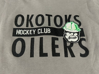 Cropped view of hoodie with OKOTOKS OILERS HOCKEY CLUB and the Okotoks Oilers' Rigger head logo embroidered on the chest.